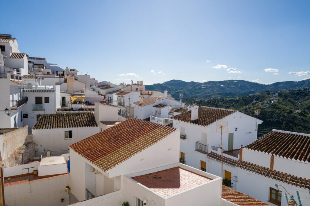 Village méditerranéen blanc, toits en tuiles, ciel bleu.