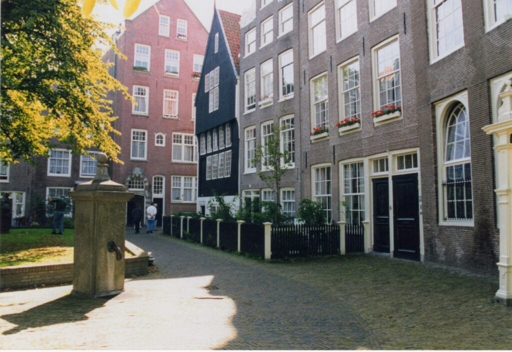 Historic Amsterdam courtyard with traditional houses and foliage.