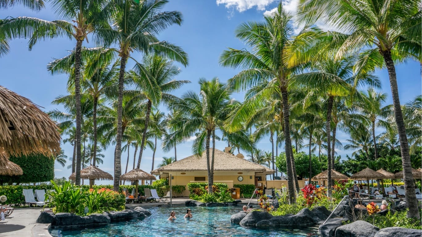 3 Essential Smart Traveler for Your Next All-Inclusive Resort Tropical resort pool with lounge chairs and umbrellas.