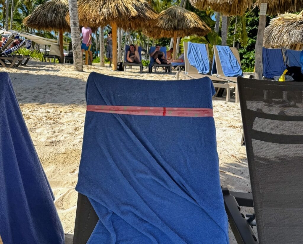 Beach chairs under thatched umbrellas on sandy beach