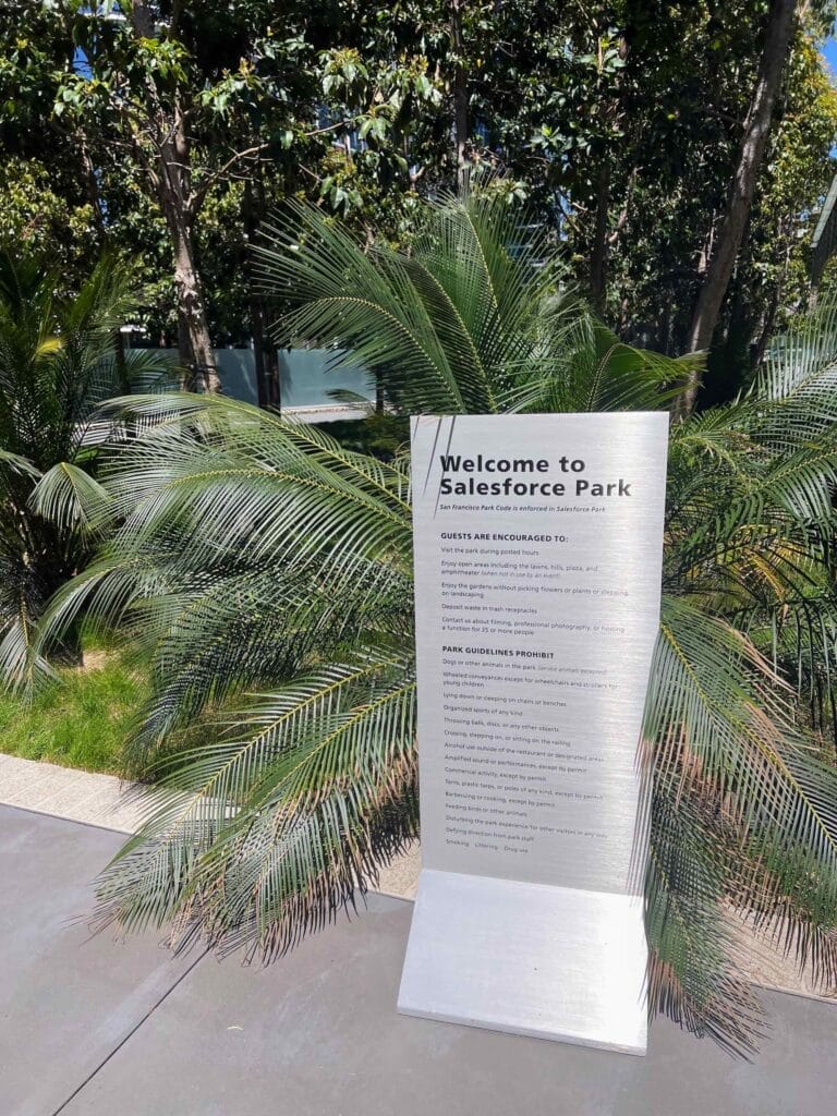 Salesforce Park welcome sign amidst lush greenery.