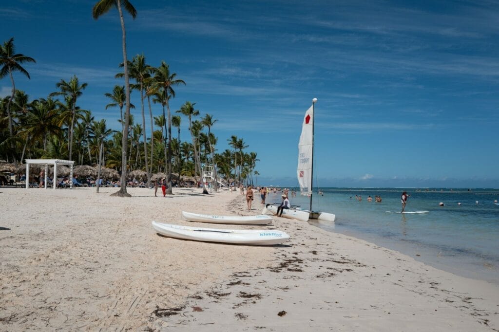 Tropical beach with palm trees and sailboats in sand