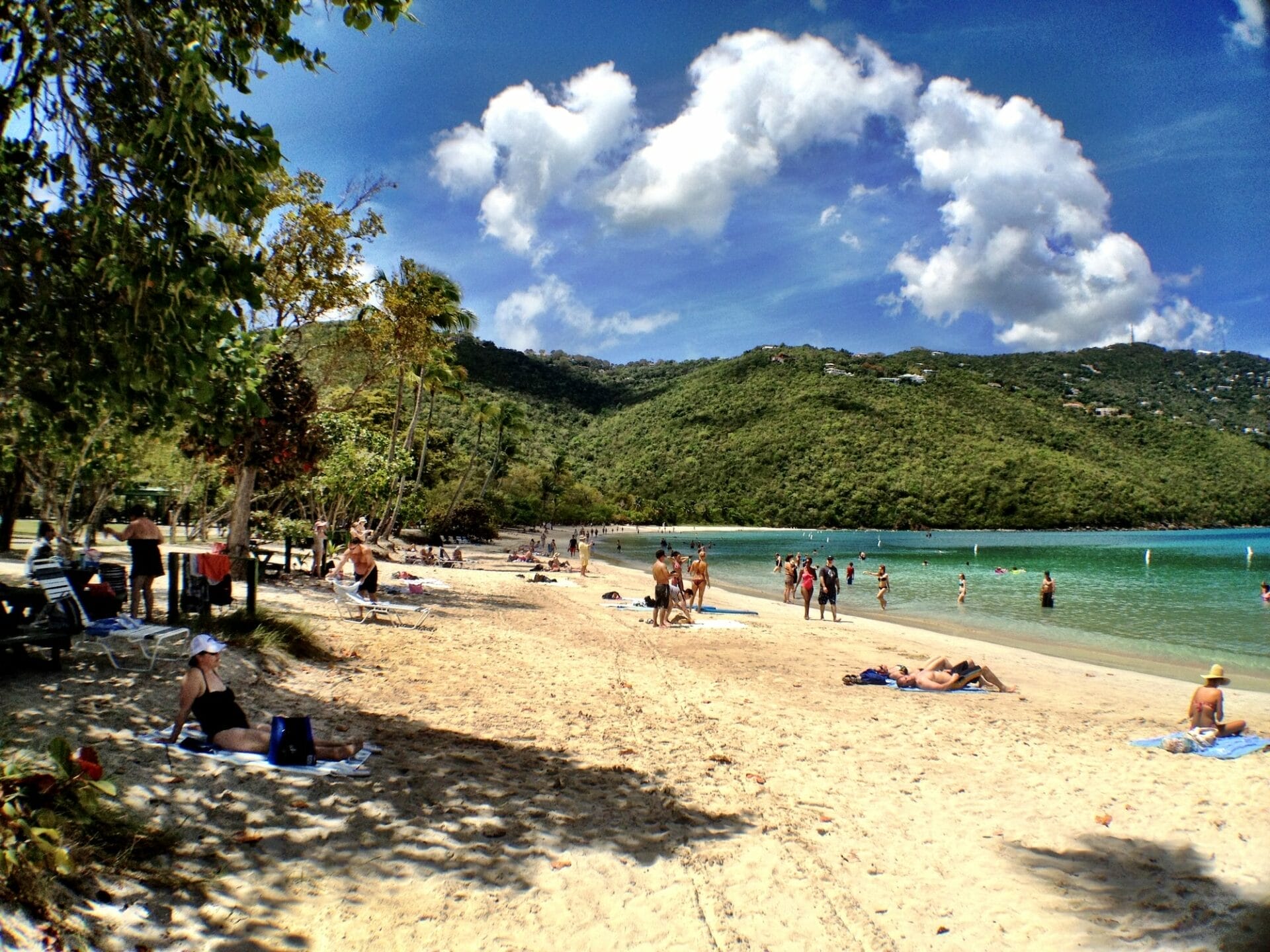Sunny beach day with people relaxing and swimming