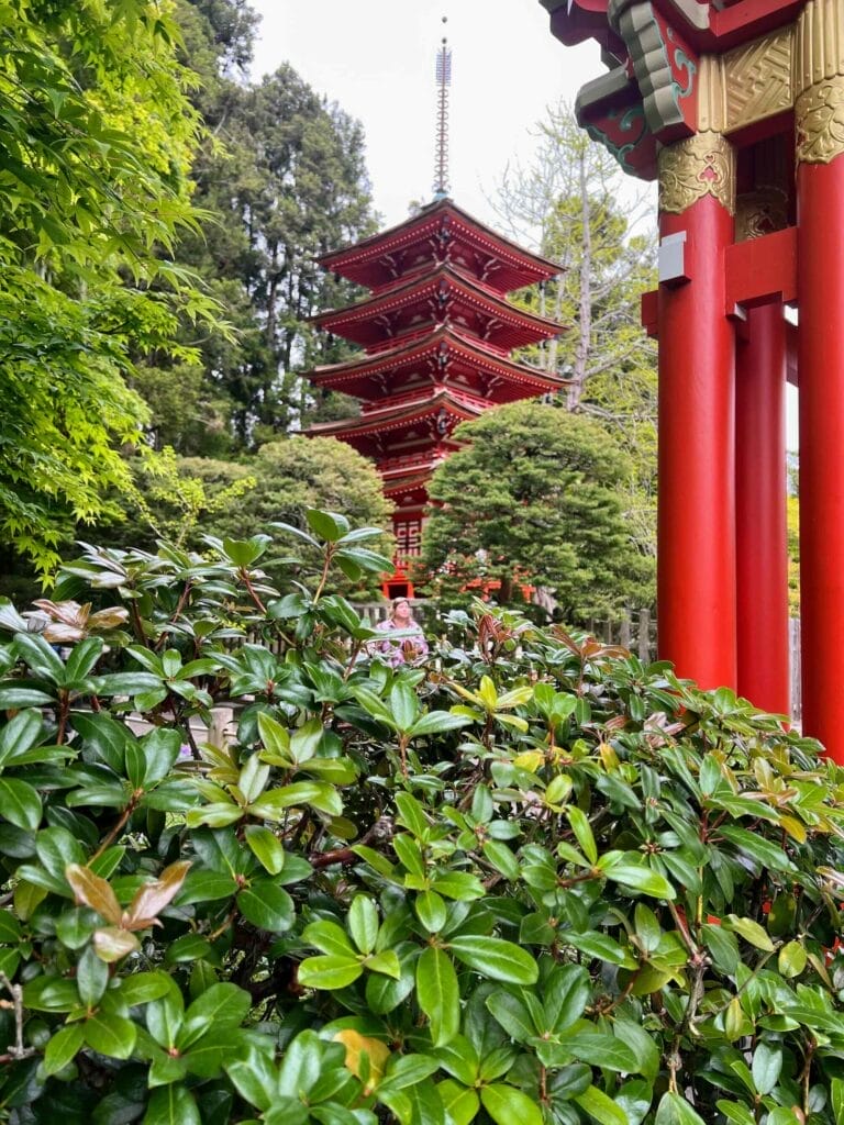 Red pagoda in lush Japanese garden